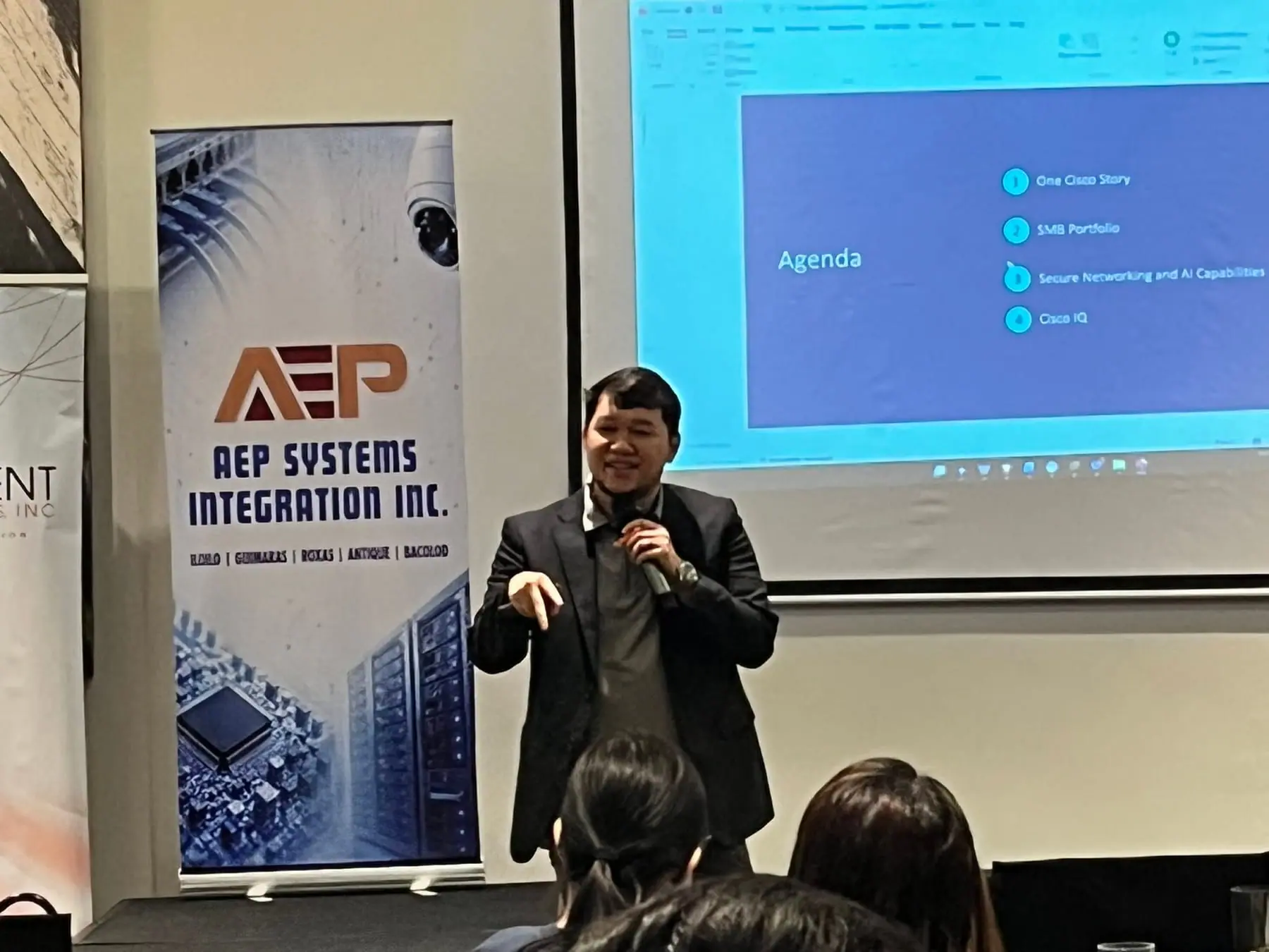 Speaker presenting in front of the AEP Systems Integration banner