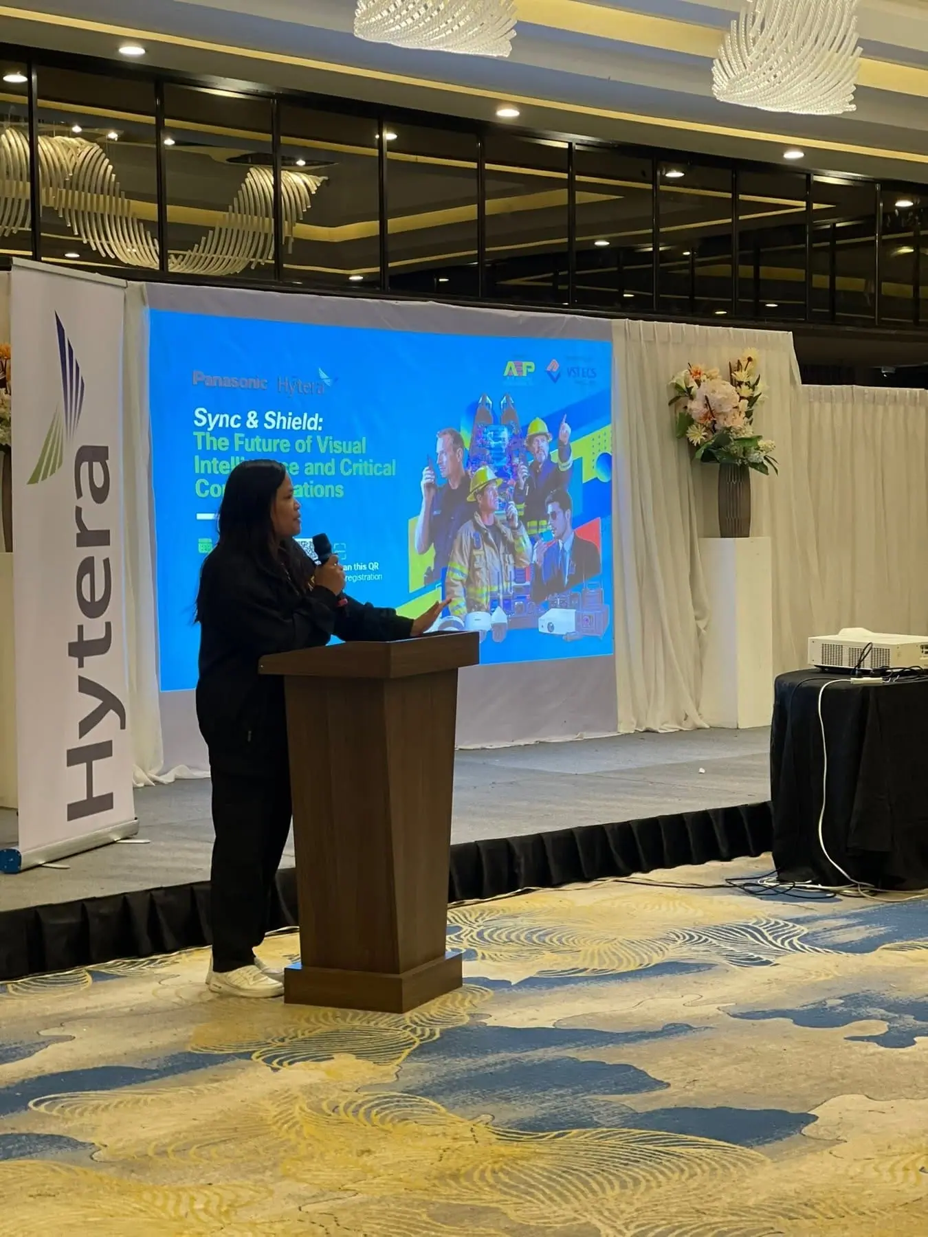 Presenter at the podium beside a Hytera banner