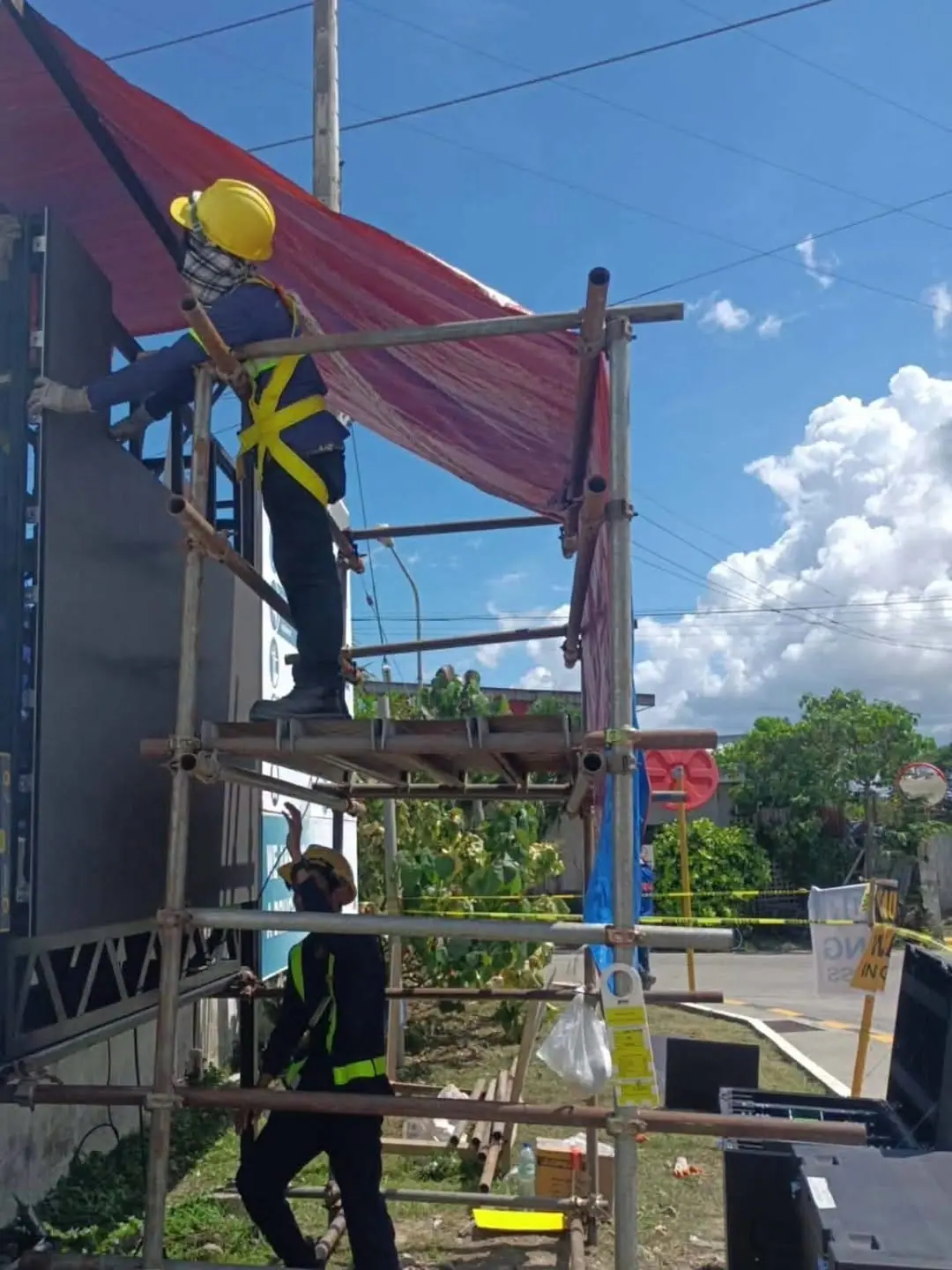Crew on scaffolding installing an outdoor LED wall